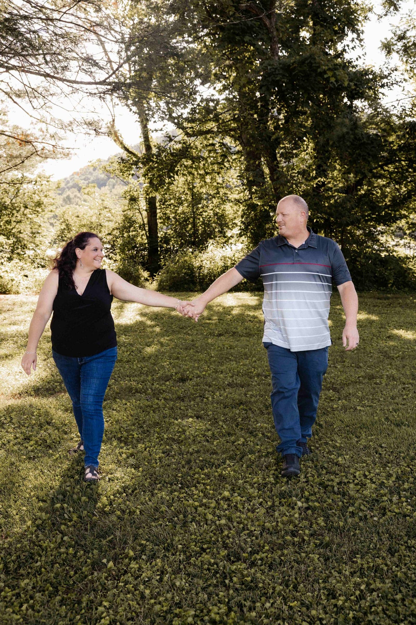 Chris and Jennifer Martin walking together through a sunlit field
