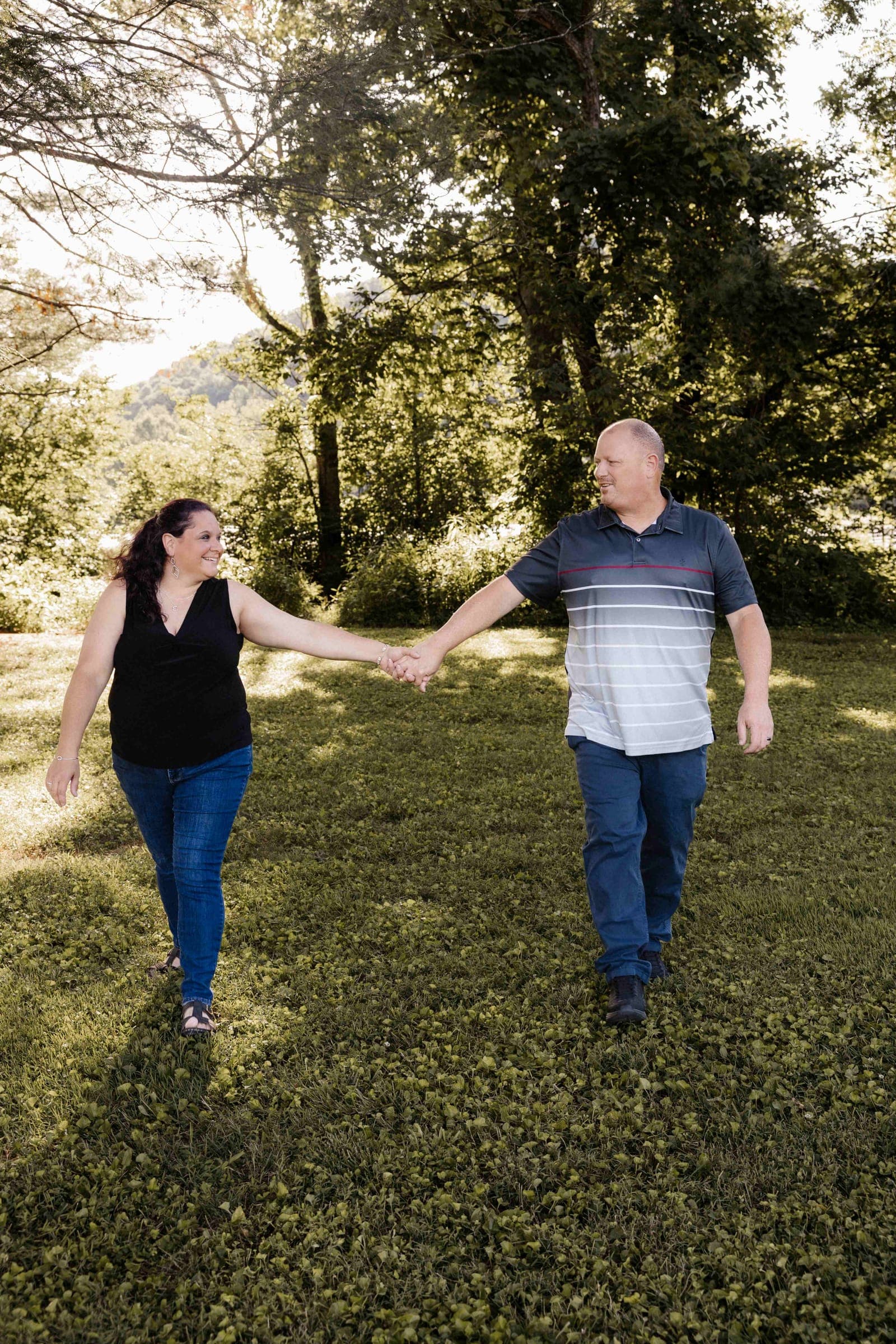 Chris and Jennifer Martin walking together through a sunlit field
