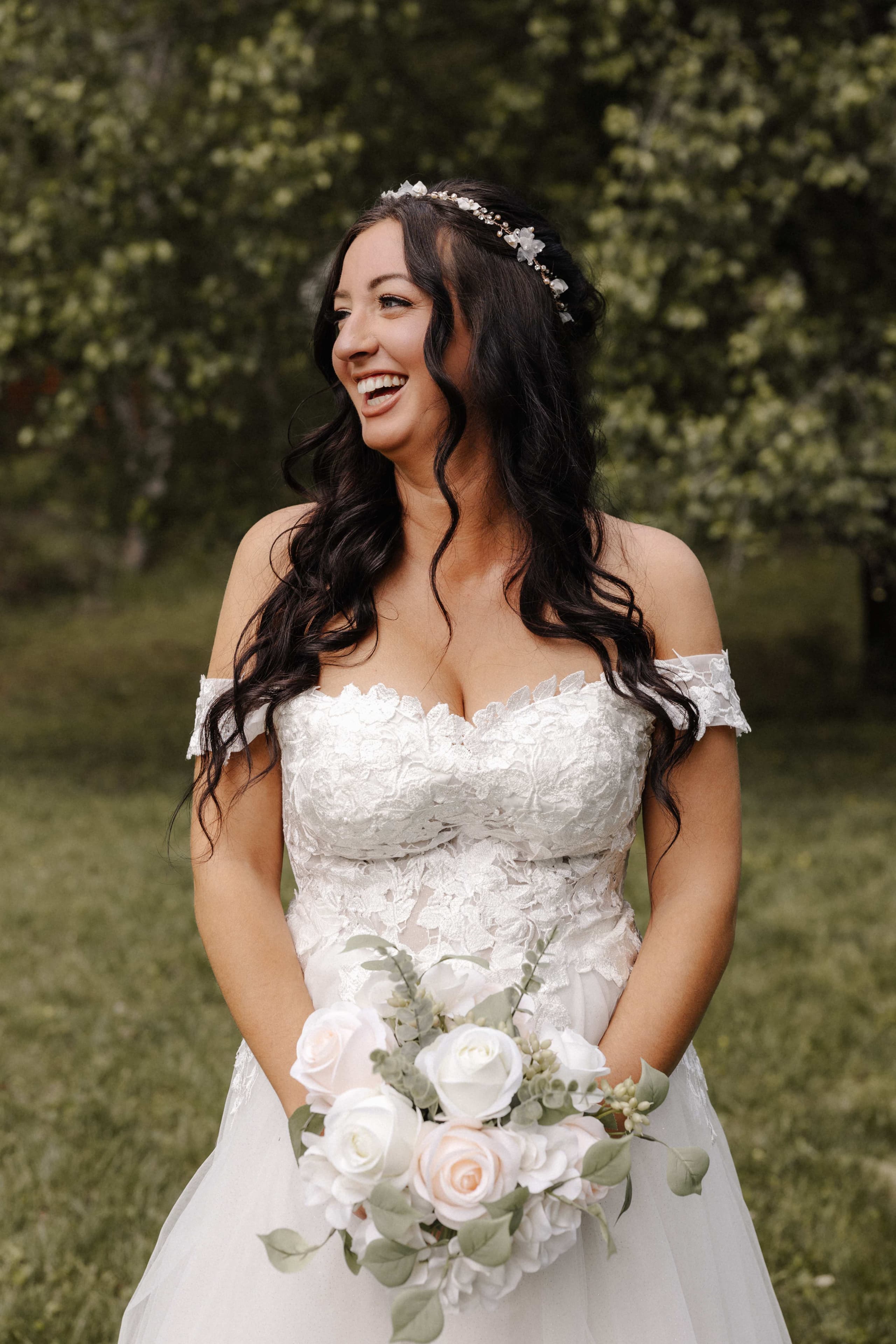 Joyful bride laughing with white and blush bouquet