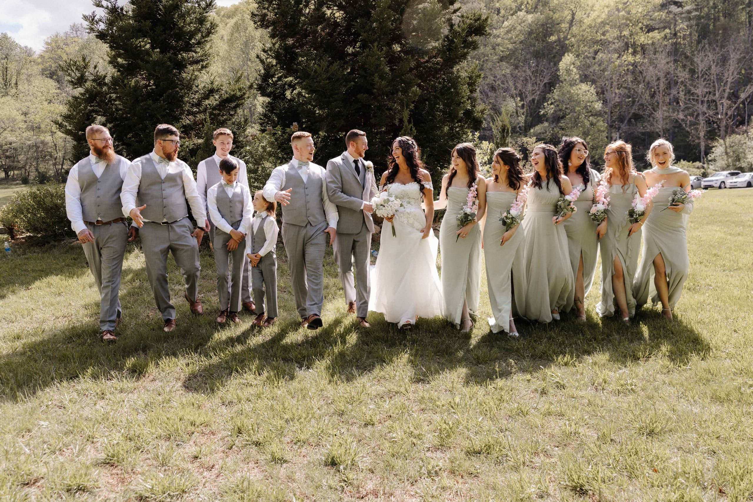 Full wedding party walking together in sage green and gray