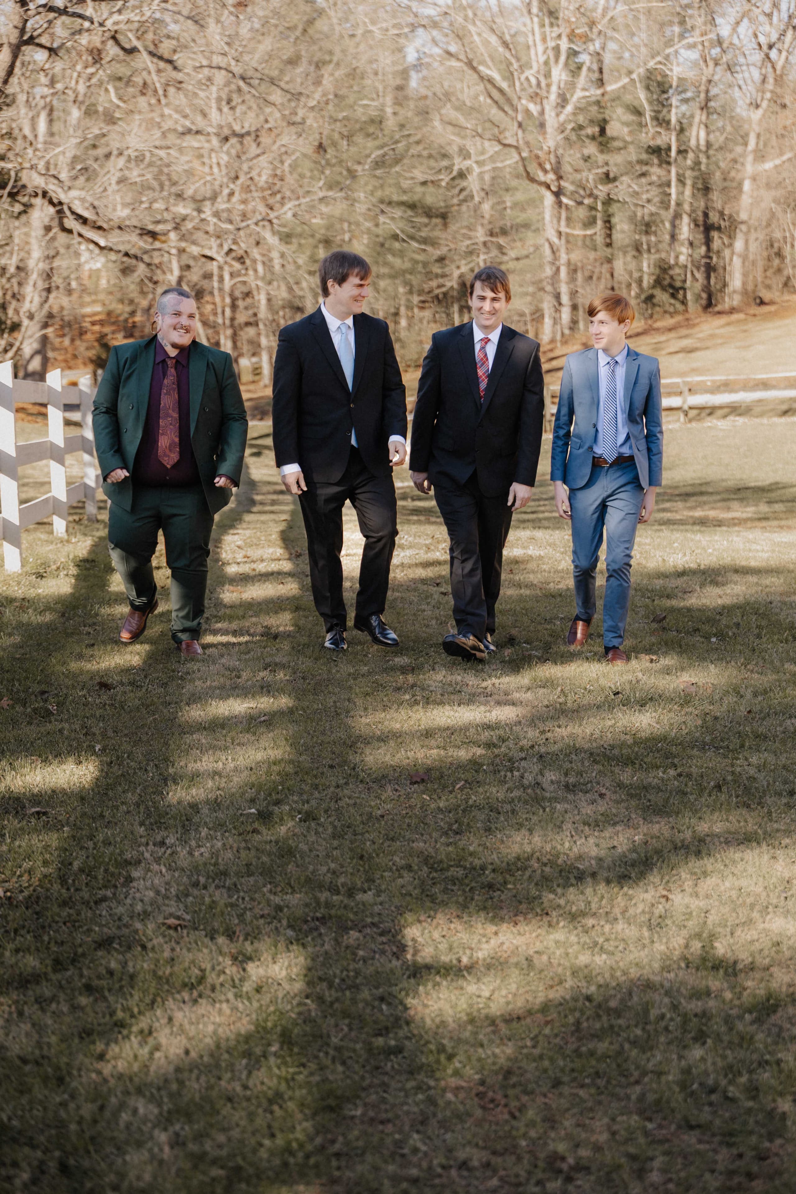 Groomsmen walking on farm in colorful suits
