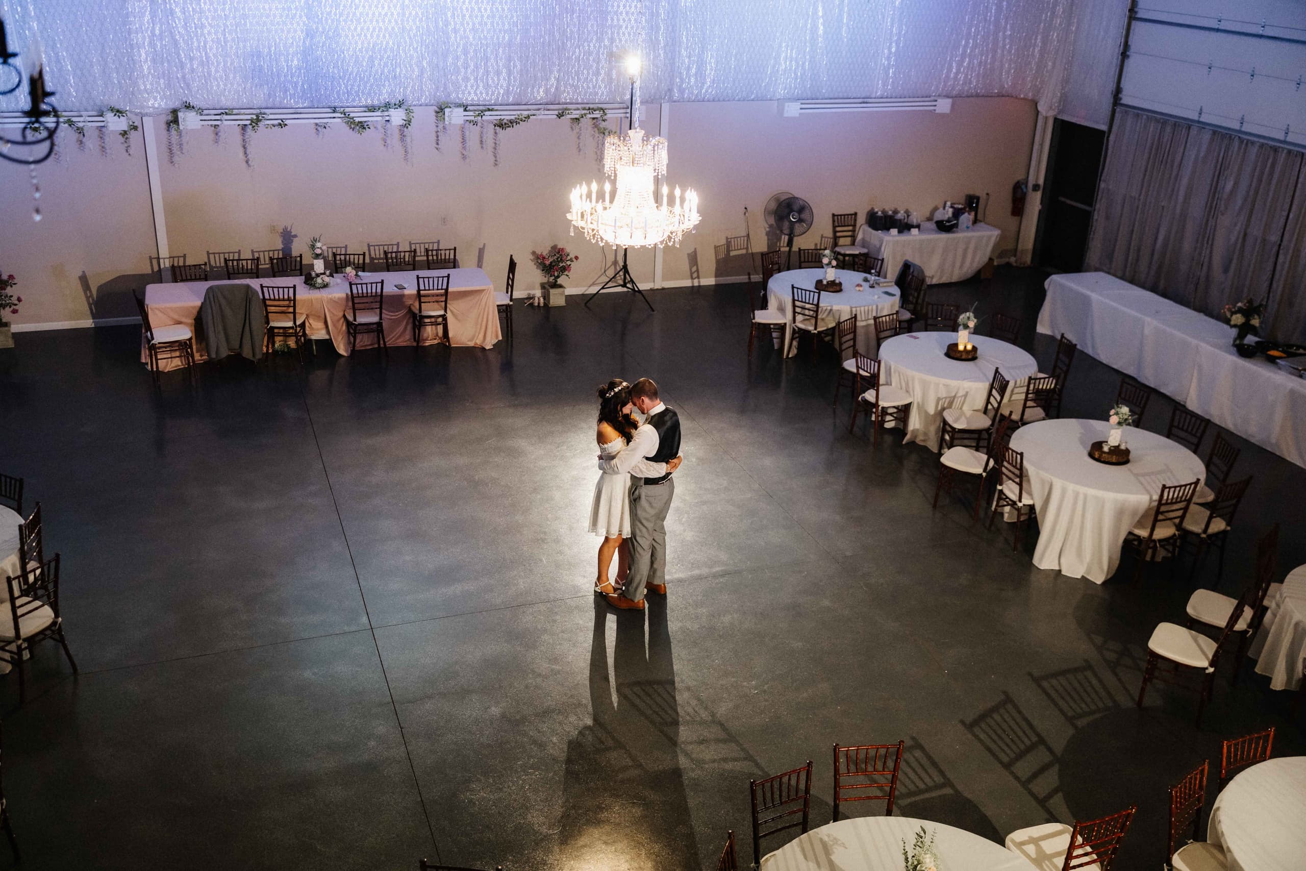 Overhead shot of first dance under chandelier in reception hall