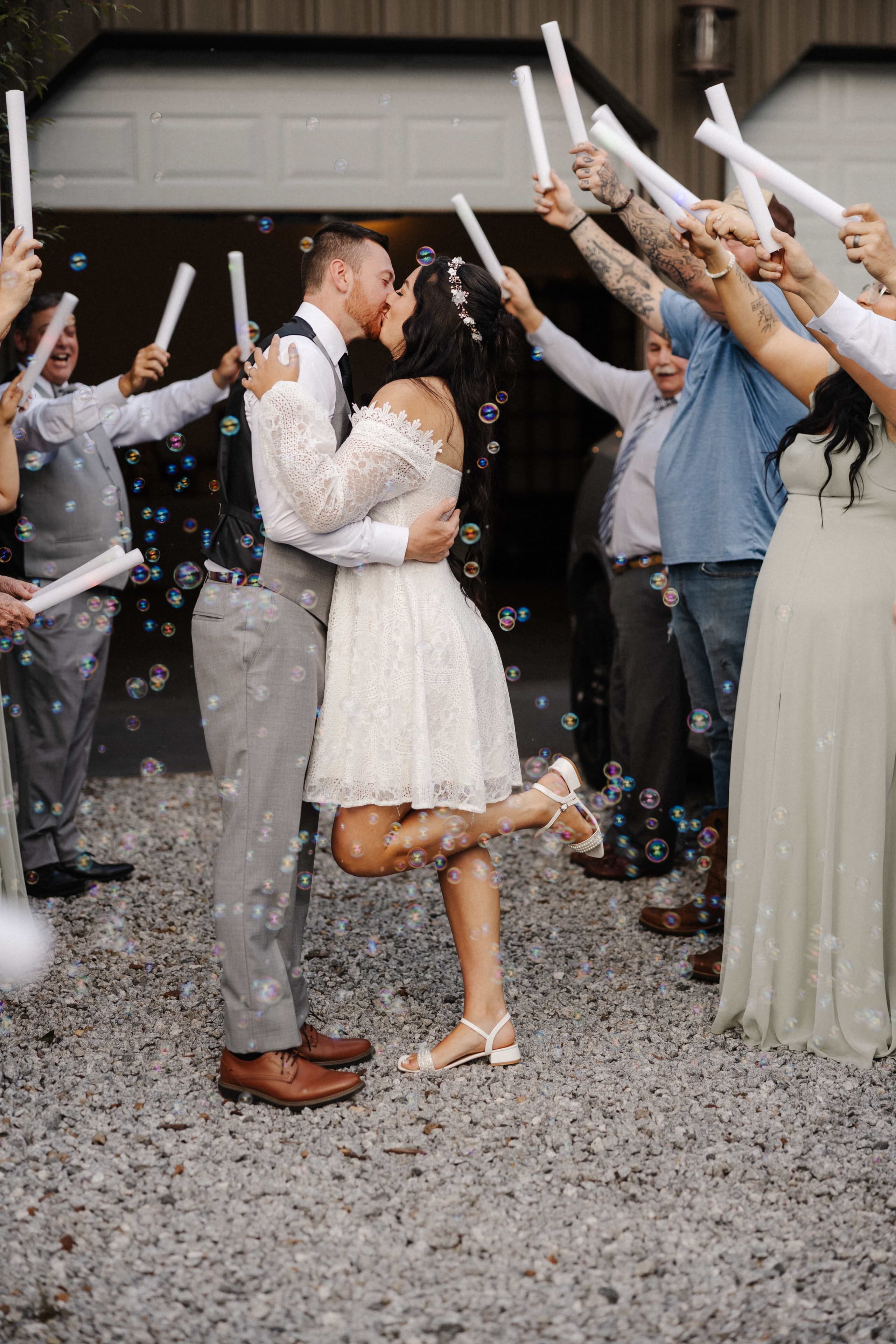Bubble exit with couple kissing and guests with glow sticks