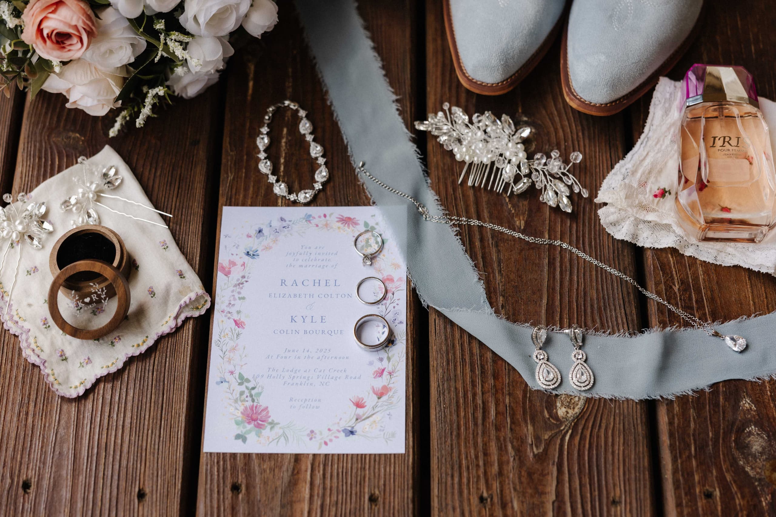 Wedding flat lay with invitation, blue cowboy boots, jewelry and perfume