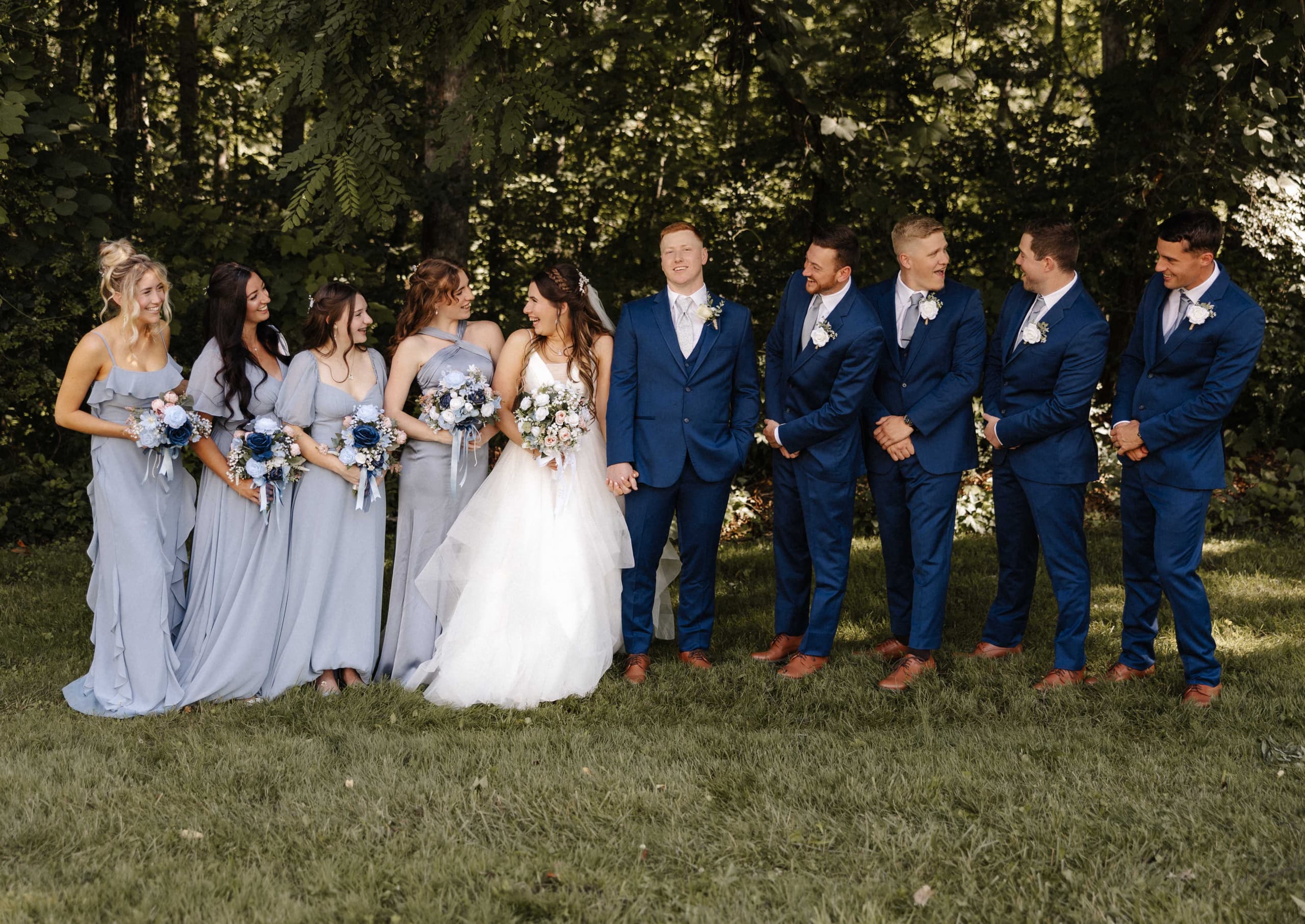 Full wedding party with dusty blue bridesmaids and navy groomsmen