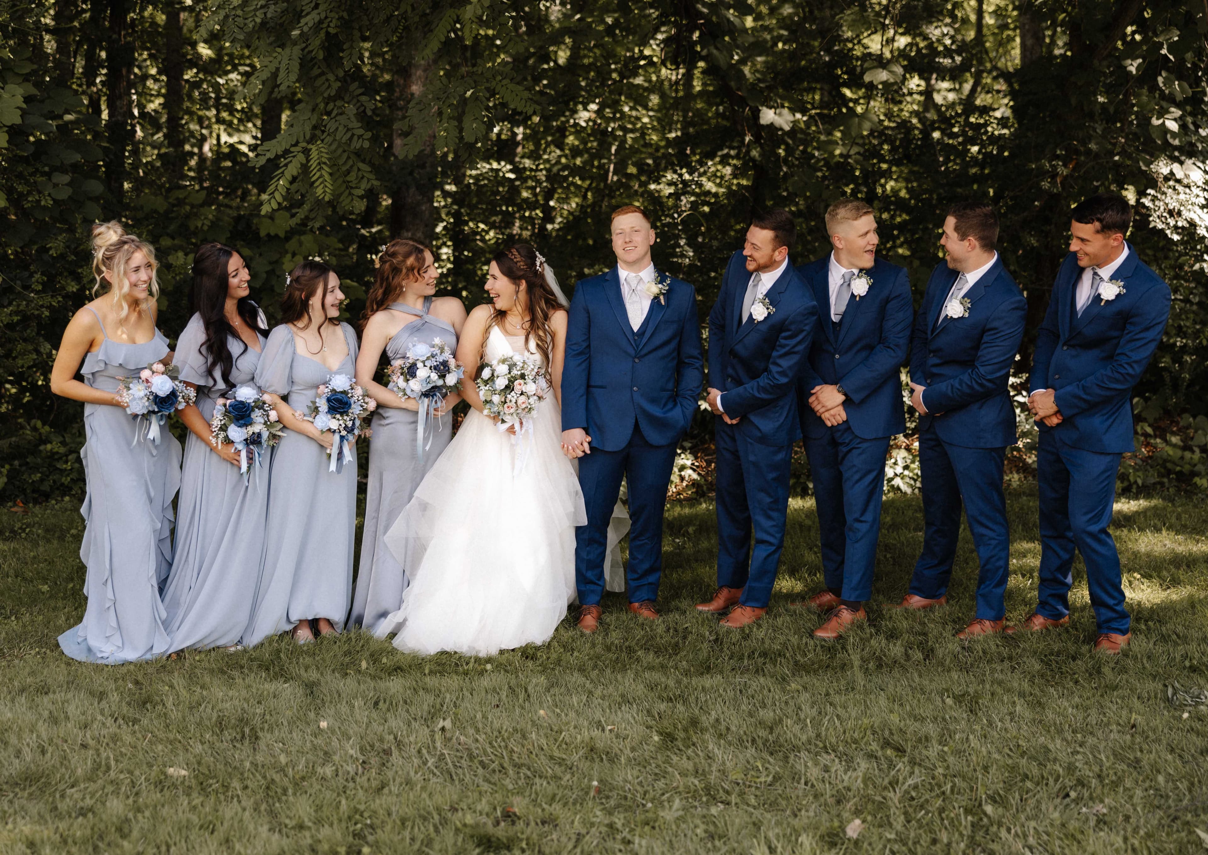 Full wedding party with dusty blue bridesmaids and navy groomsmen