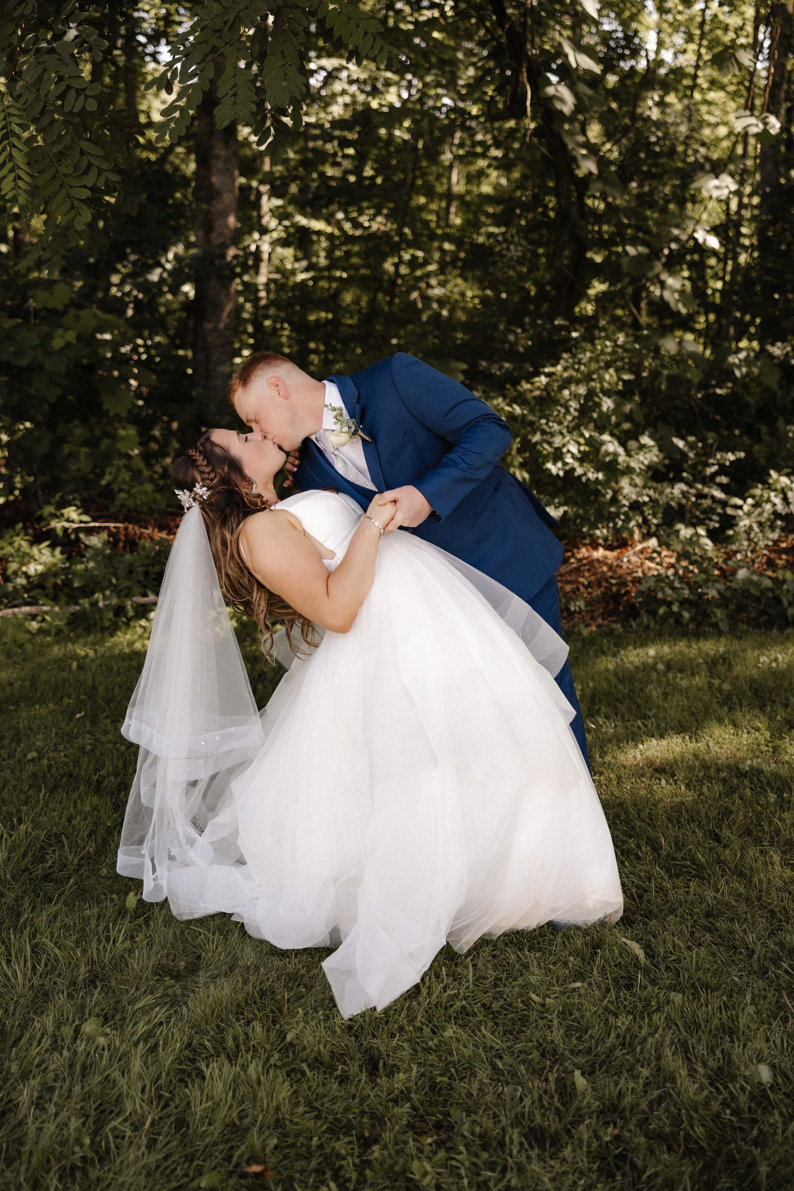 Romantic dip kiss in forest with flowing veil
