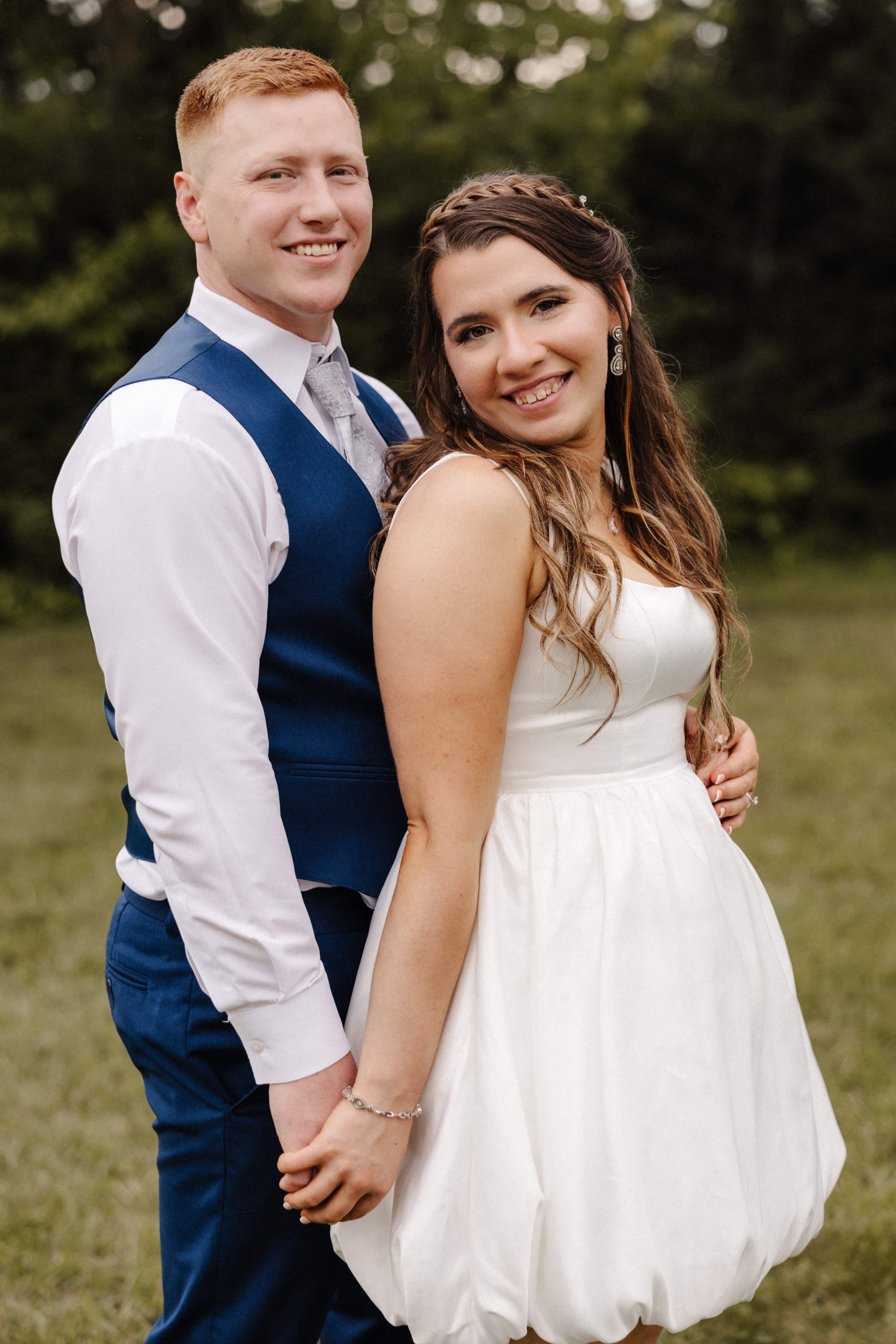Couple portrait in short reception dress smiling at camera