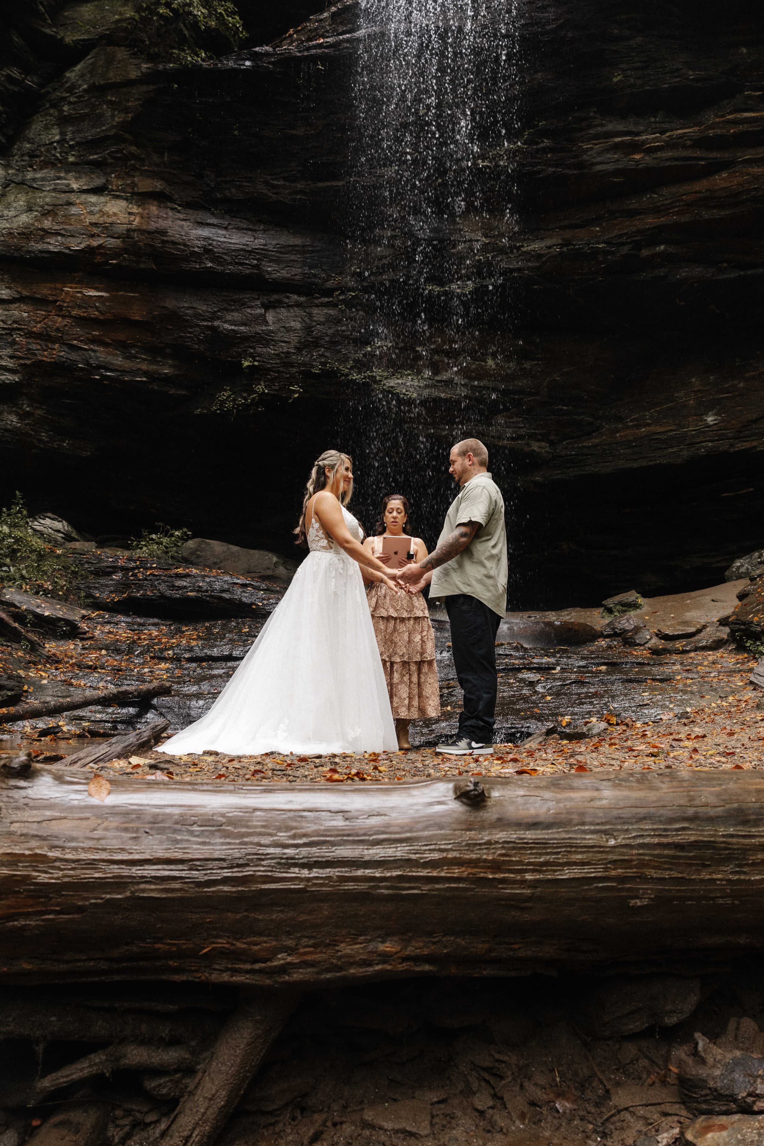 Waterfall ceremony with couple exchanging vows on rocks