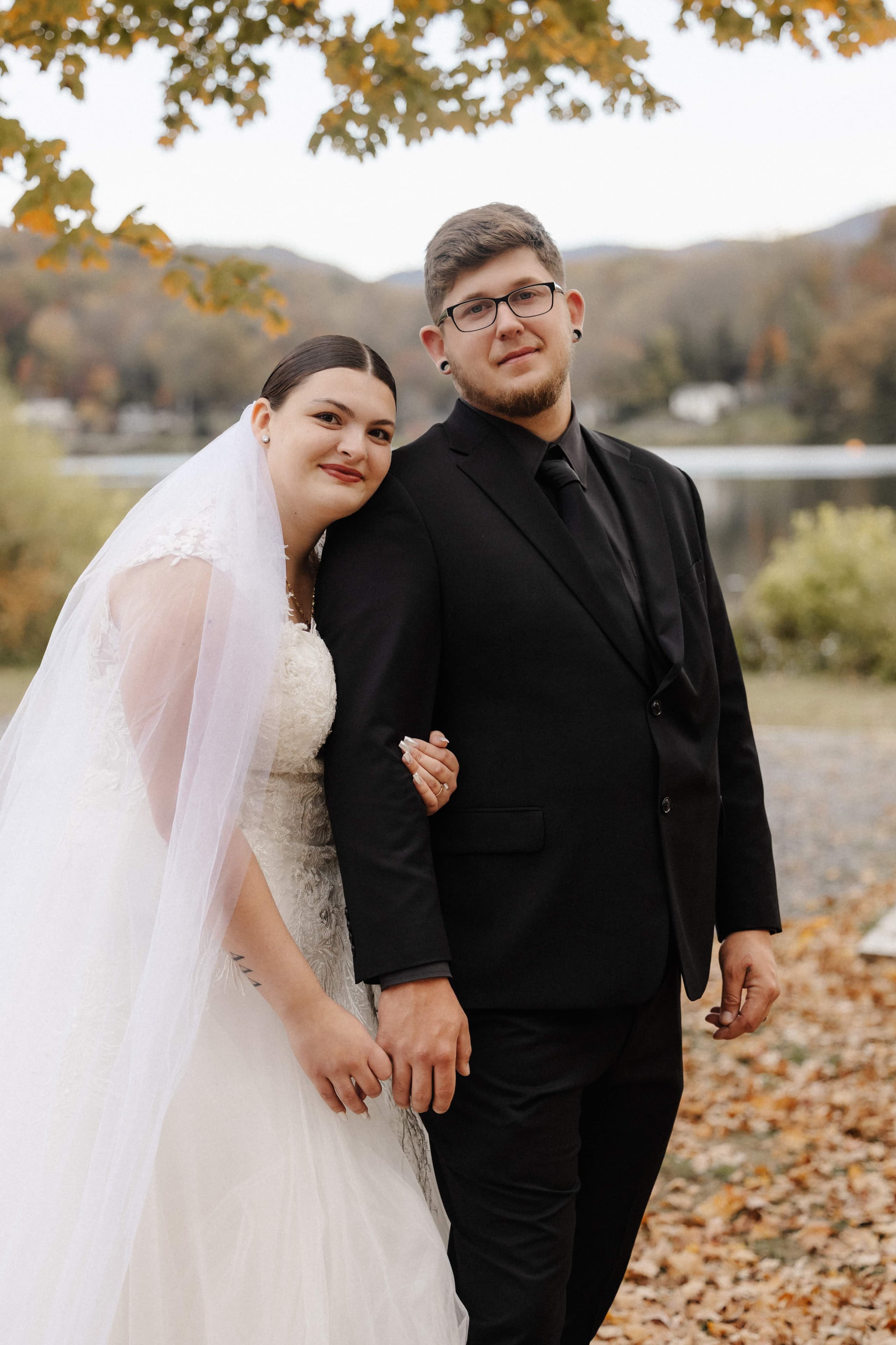 Couple portrait by lake with fall foliage and mountains
