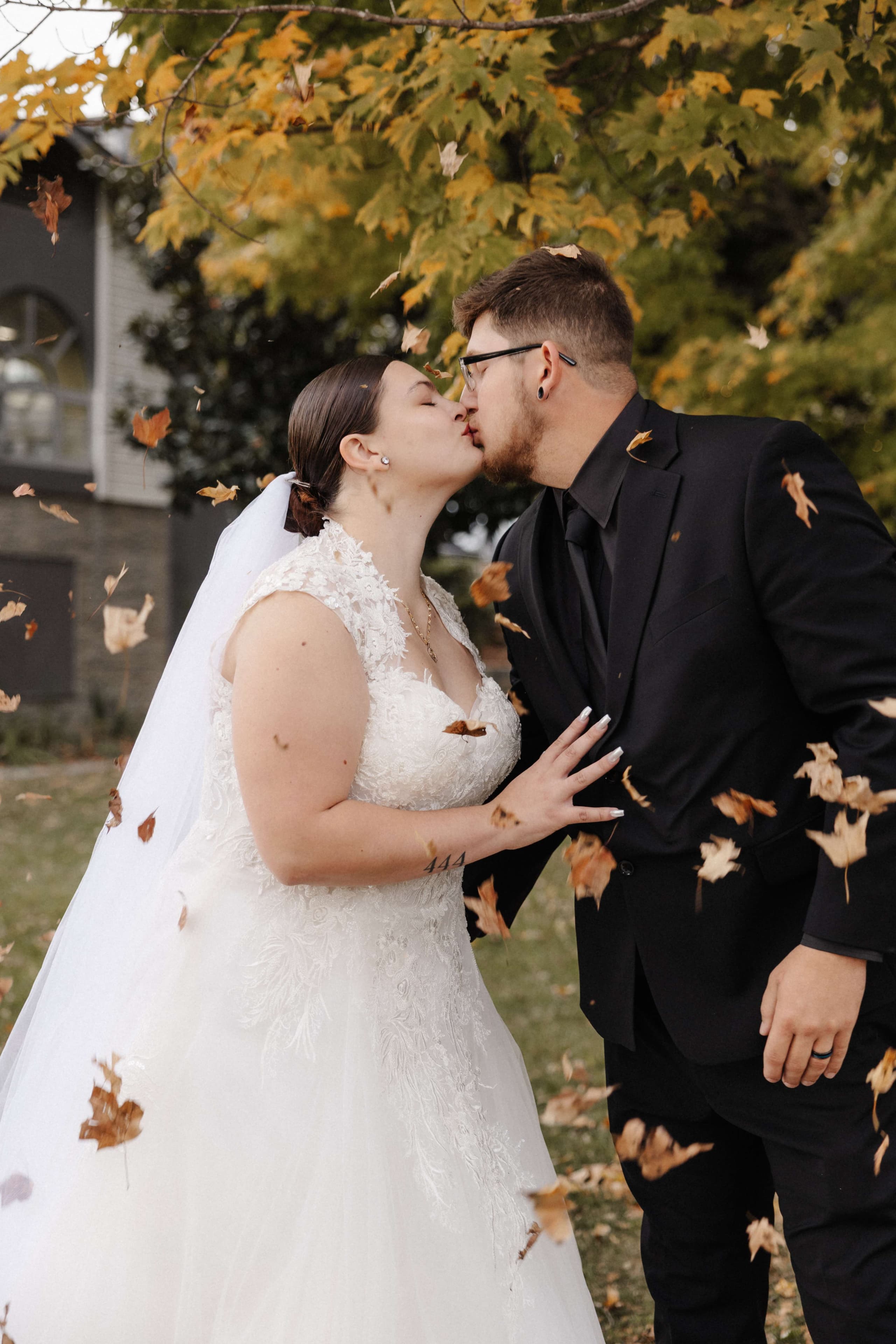 Couple kissing with fall leaves falling around them