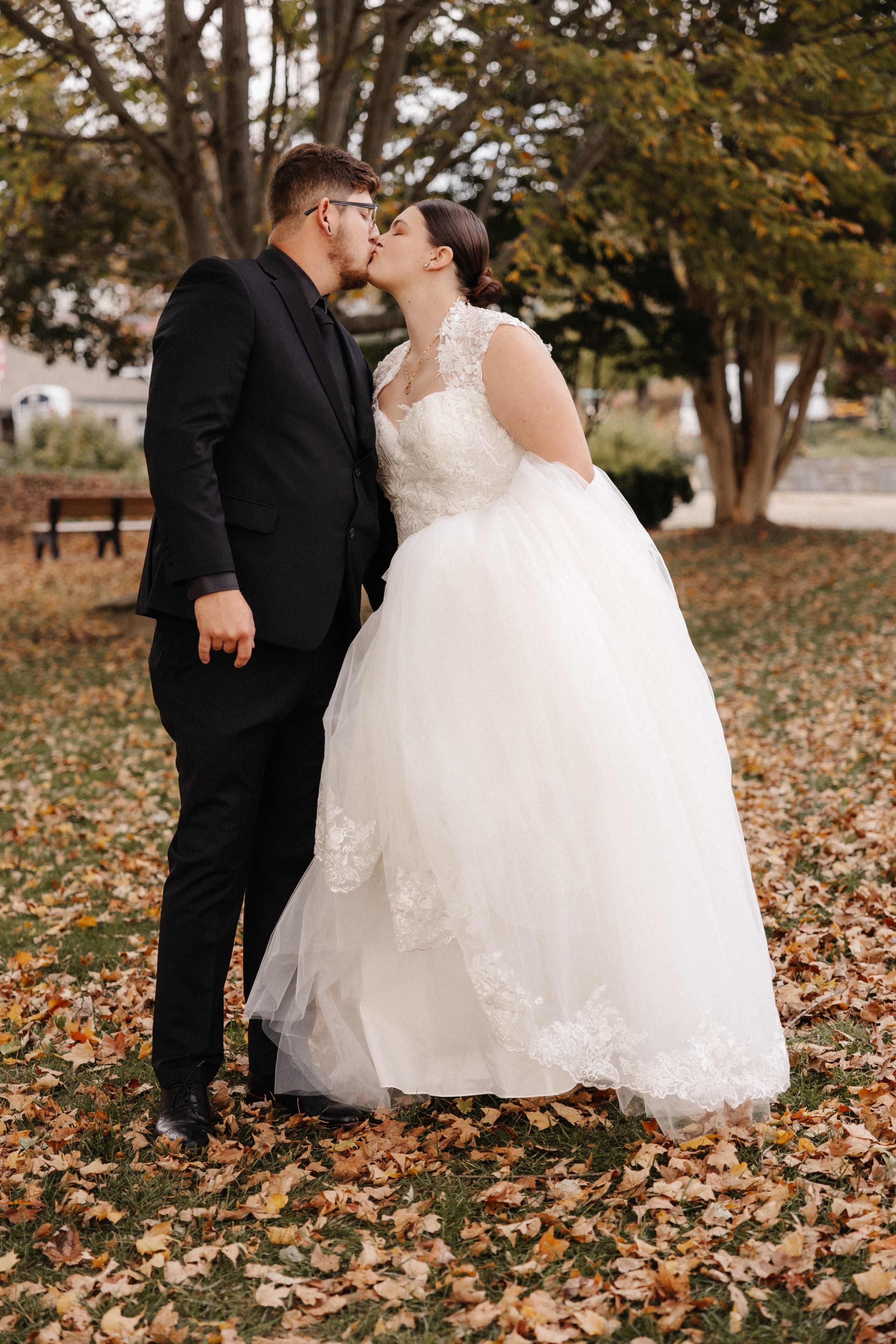 Couple kissing among fall leaves in park