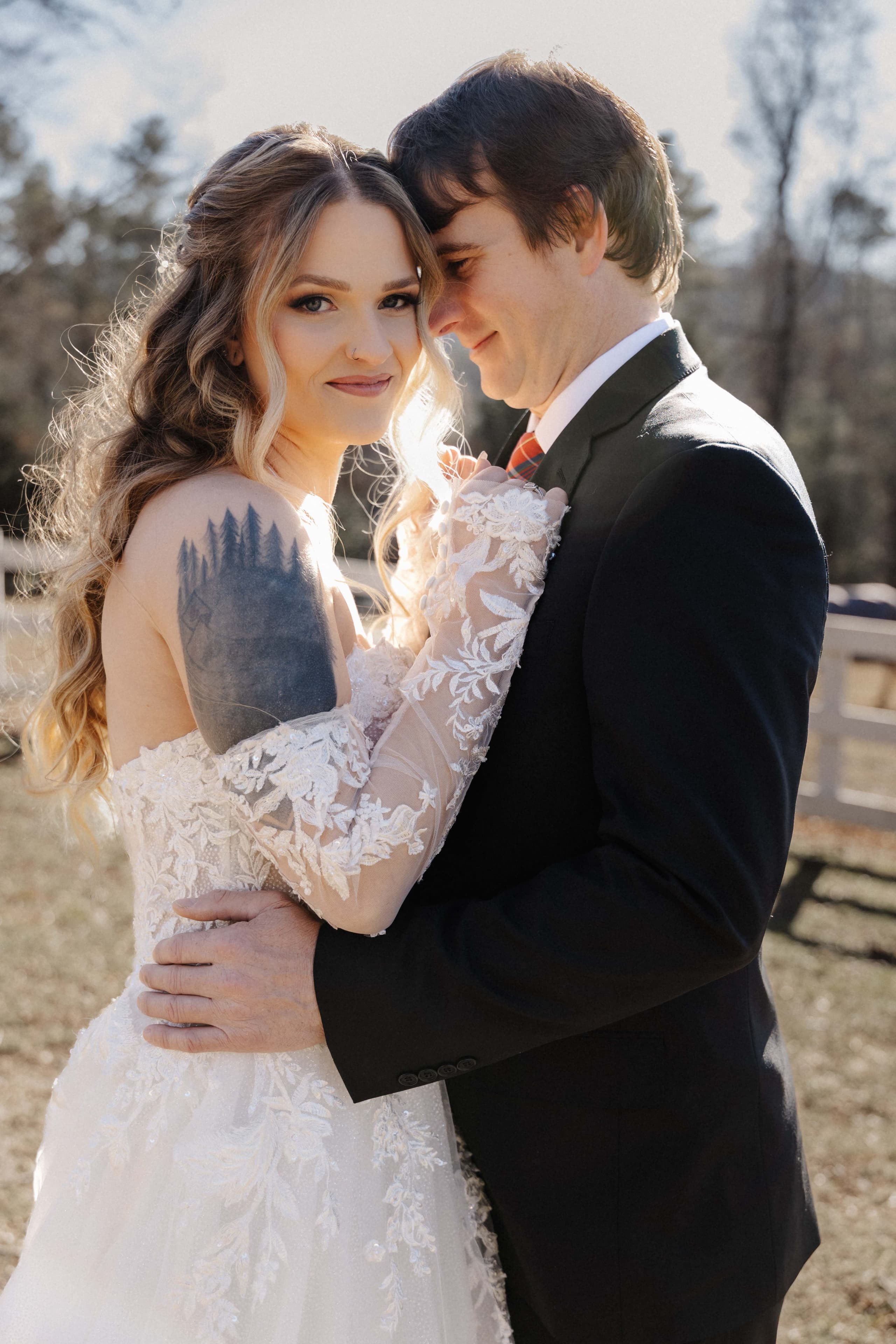 Intimate couple portrait with golden backlight showing bride's tree line tattoo