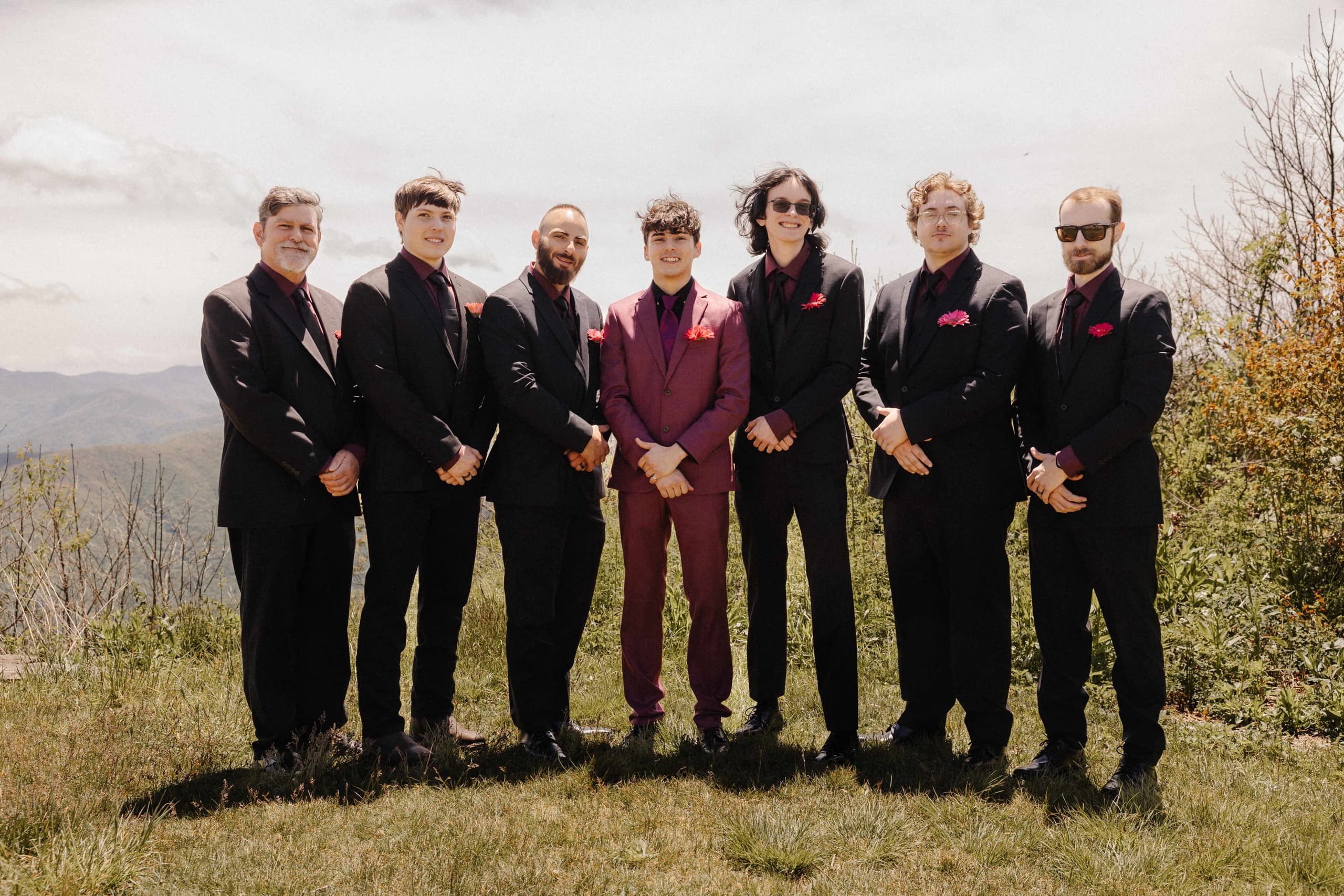 Groom with groomsmen formal portrait in burgundy and black suits