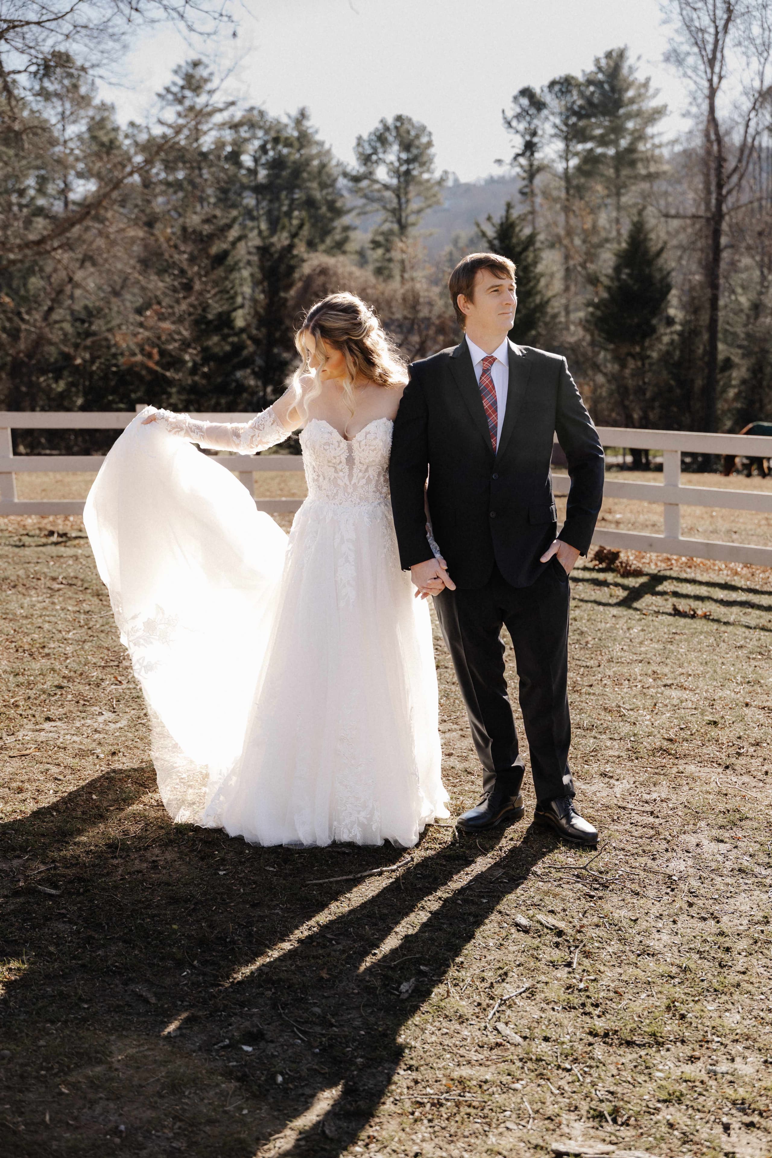 Couple portrait on farm with bride's dress flowing in wind