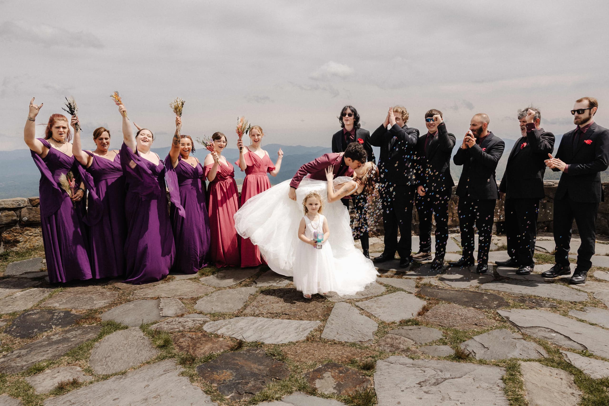 Wedding party celebrating with bubbles and dip kiss