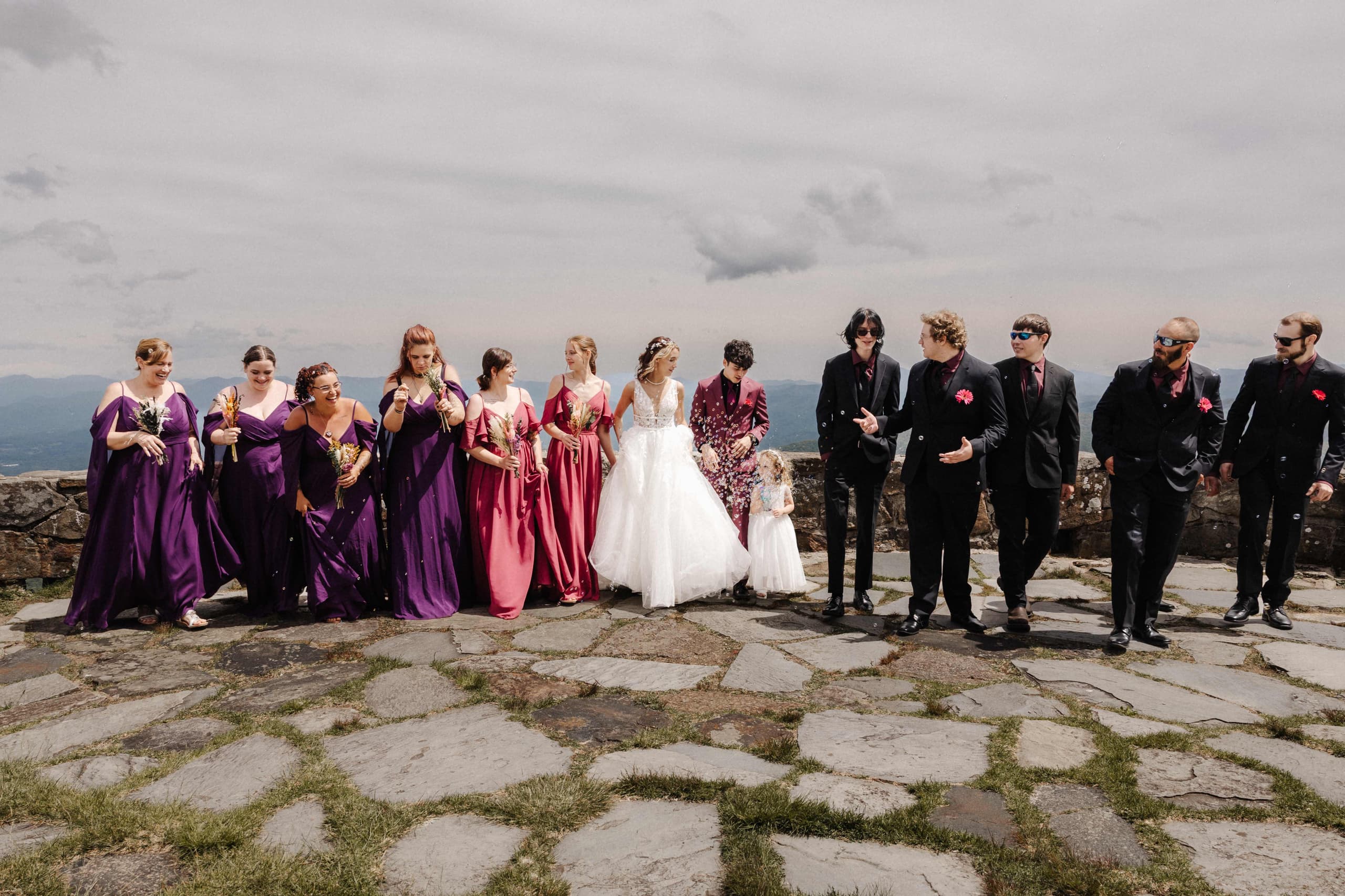 Full wedding party walking together candid shot on mountain