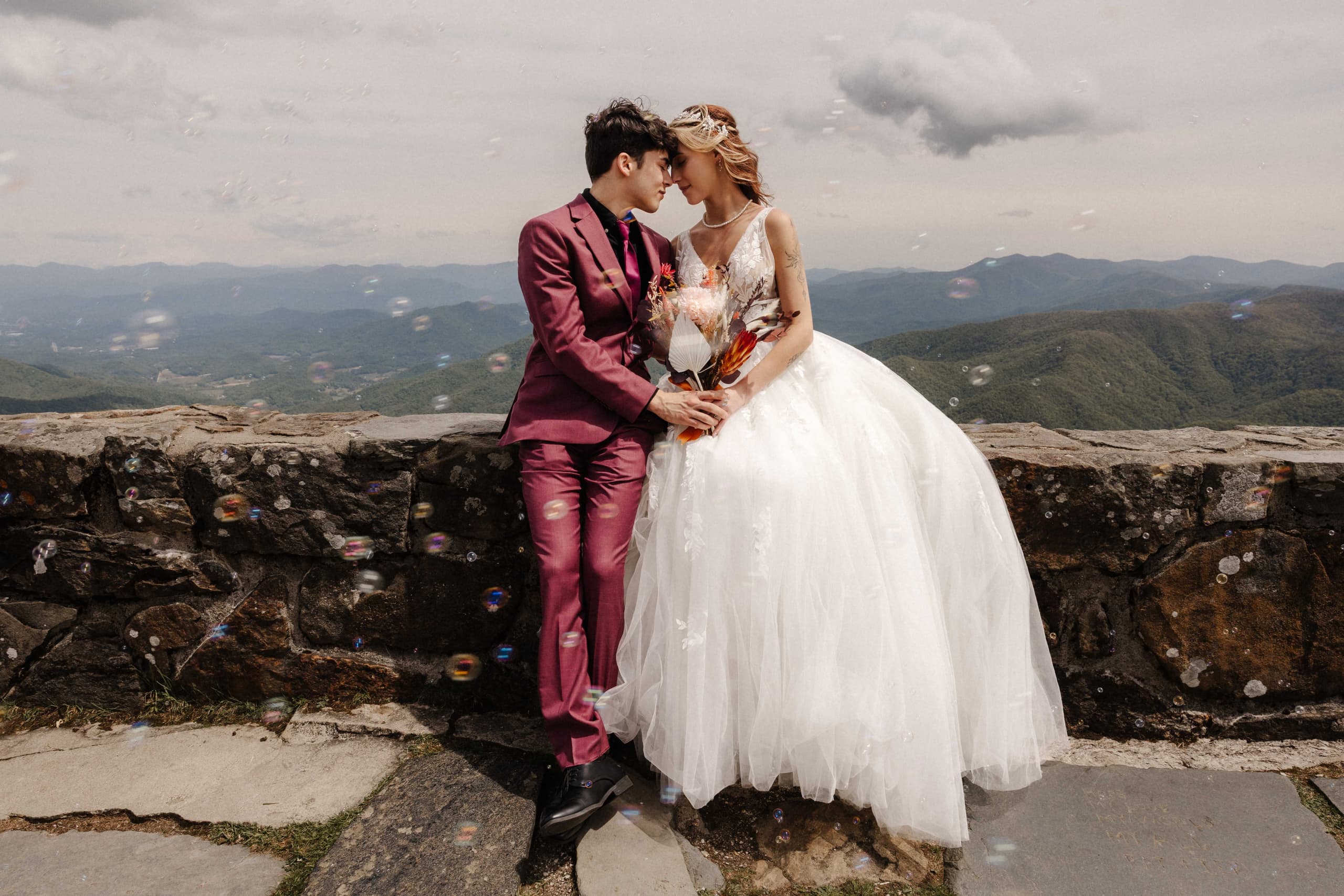 Couple portrait with bubbles floating around them and mountain views
