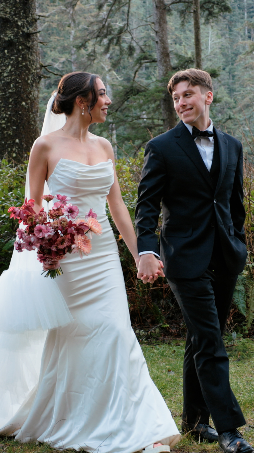 Bride and groom holding hands in mossy forest